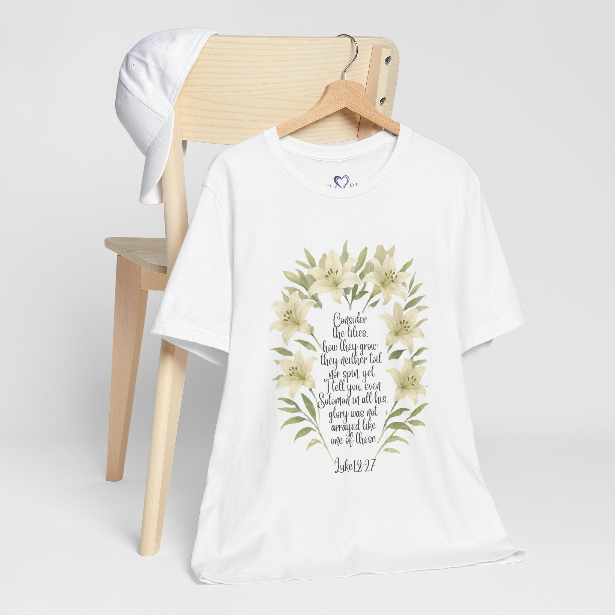 “Watercolor lily Christian t-shirt featuring Luke 12:27. A soft, faith-inspired reminder to trust God’s care. Beautiful gift for women of faith, Bible study, or everyday encouragement.”