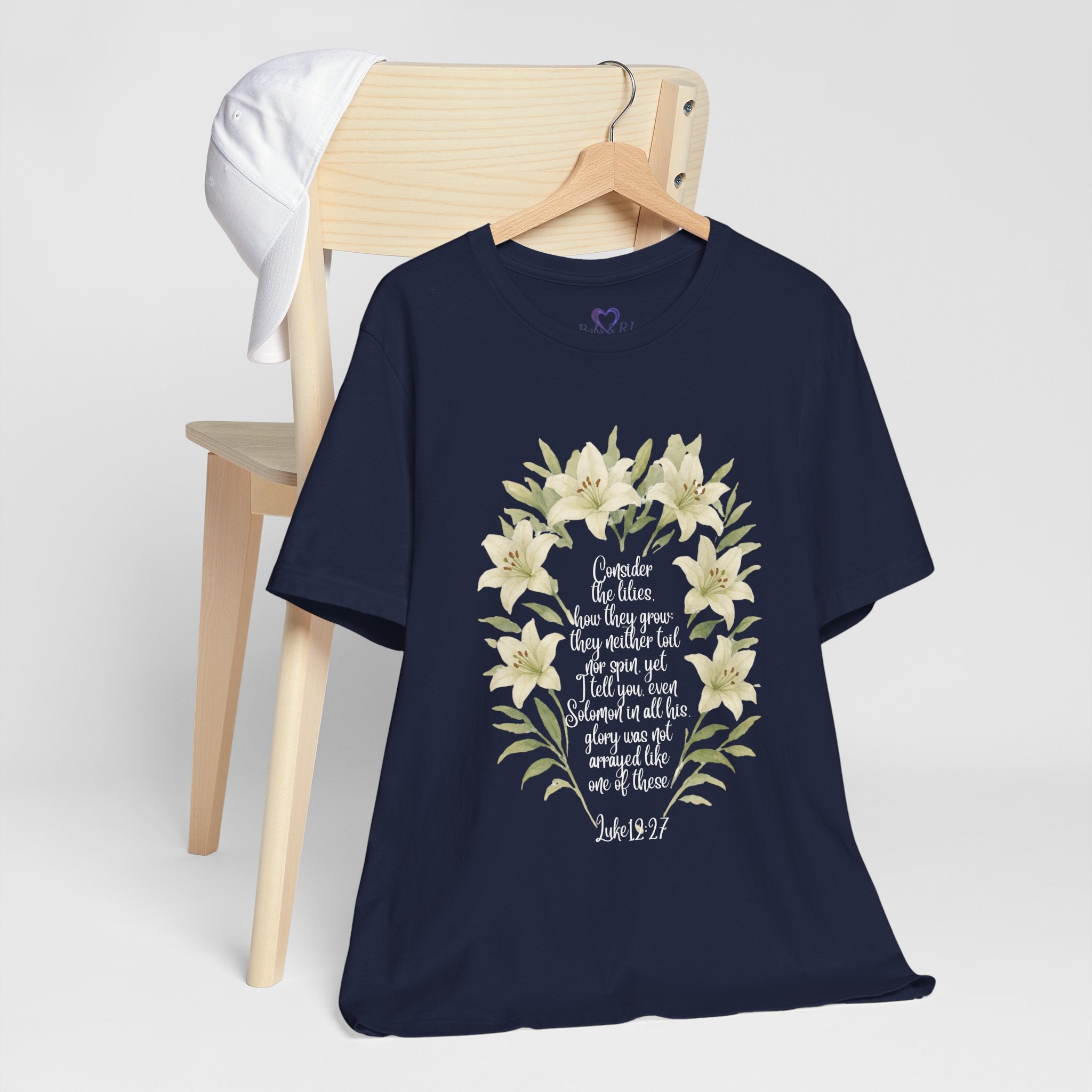 “Watercolor lily Christian t-shirt featuring Luke 12:27. A soft, faith-inspired reminder to trust God’s care. Beautiful gift for women of faith, Bible study, or everyday encouragement.”